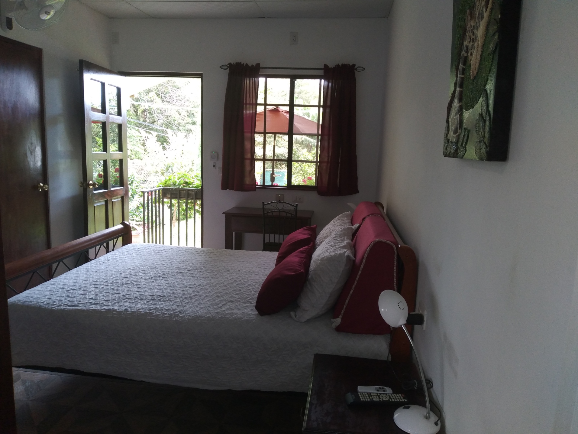 Bedroom view at the bed, desk and open terrace door