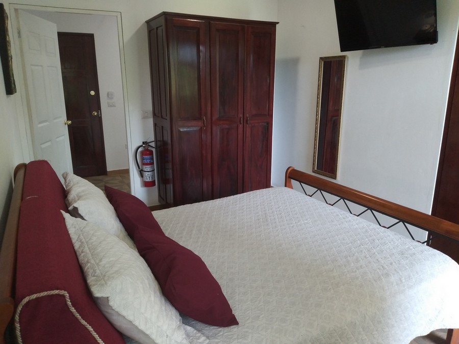 Bedroom view at the closet, smart tv and open door to the kitchen