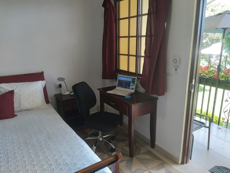 bedroom with laptop on desk and comfortable office chair